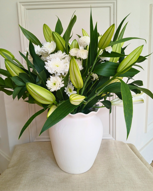 Sympathy flowers with options of classic whites with lillies or deep purple and oranges available for delivery to bromborough and all Wirral and Liverpool addresses 