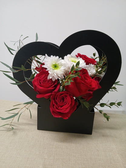 Floral arrangement with red and white flowers in a black heart-shaped box available for Wirral Delivery 